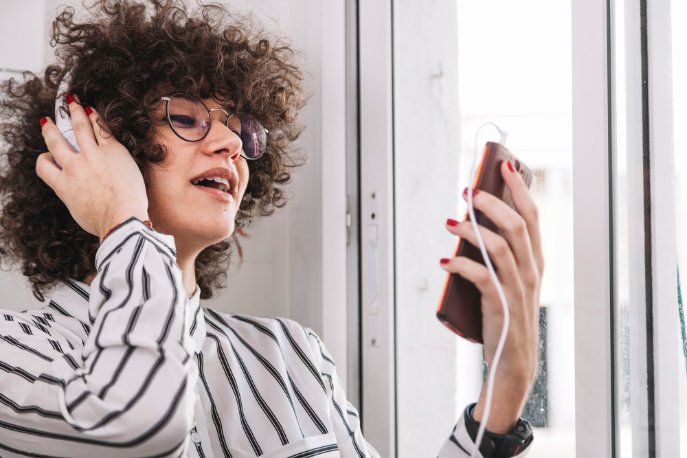 Jovem com fones praticando sozinha sua comunicação no autoconceito.